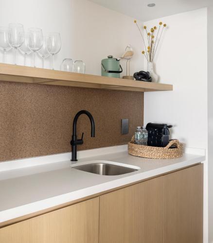 a kitchen with a sink and glasses on a shelf at Newport Harbor Island Resort in Newport