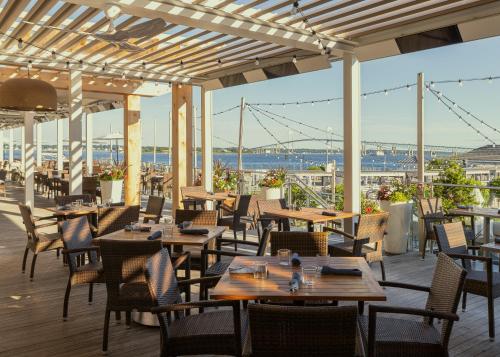 a restaurant with tables and chairs and a view of the water at Newport Harbor Island Resort in Newport
