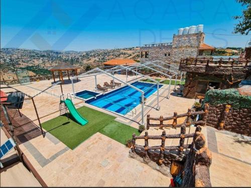 ein Haus mit einem Pool und einem Spielplatz in der Unterkunft tal alazaraq in Salt