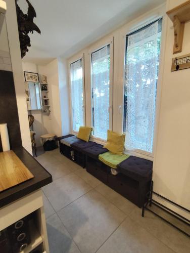 - un salon avec deux bancs devant les fenêtres dans l'établissement Joli studio avec cour intérieure, à Aix-les-Bains