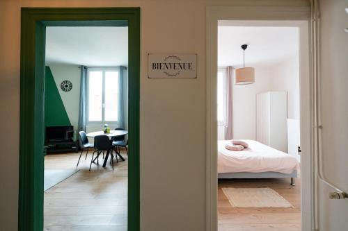 a bedroom with a bed and a room with a table at Appartement Centre-Ville 2/4 personnes in Épernay