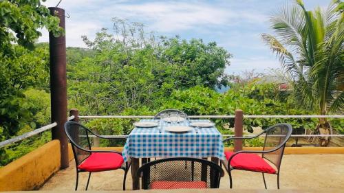 a table and chairs sitting on a balcony with a view of trees at Casa Macondo in Puerto Ángel