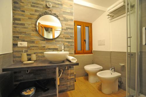 a bathroom with a sink and a toilet and a mirror at La Corte di GreSi in Tivoli