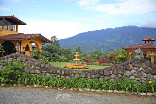 a garden with a stone wall and a fountain at Los Establos Boutique Resort - All Inclusive in Boquete