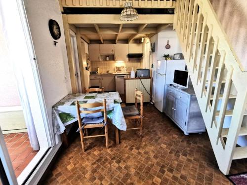 une petite cuisine avec une table et un réfrigérateur dans l'établissement Résidence Maisons Des Sables 4 - APPT T2 CAB OU MEZZ 5 couchages PORT LEUCATE MAE-4931, à Leucate