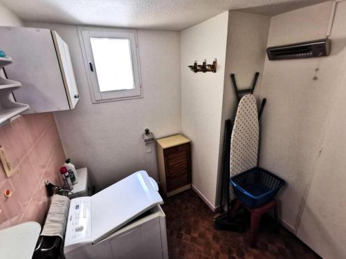 Cette petite chambre comprend une petite cuisine avec une chaise. dans l'établissement Résidence Maisons Des Sables 4 - APPT T2 CAB OU MEZZ 5 couchages PORT LEUCATE MAE-4931, à Leucate