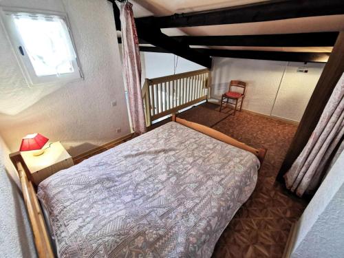 une chambre avec un lit, une fenêtre et une chaise dans l'établissement Résidence Maisons Des Sables 4 - APPT T2 CAB OU MEZZ 5 couchages PORT LEUCATE MAE-4931, à Leucate