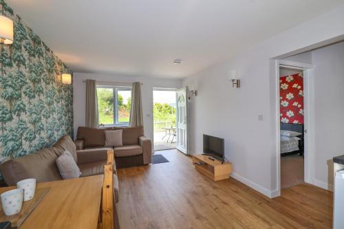 a living room with a couch and a tv at Widgeon in Highbridge