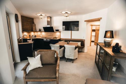 a living room with a kitchen and a living room with a table at Chalet Serles in Mieders