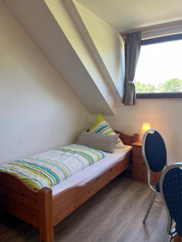 a bedroom with a bed and two chairs and a window at Ferienwohnung Burg Maus in Lahnstein