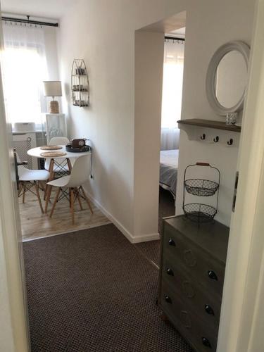 a room with a bedroom with a table and a dresser at Pod Aniołem in Mielno
