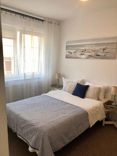 a bedroom with a large bed and a window at Pod Aniołem in Mielno