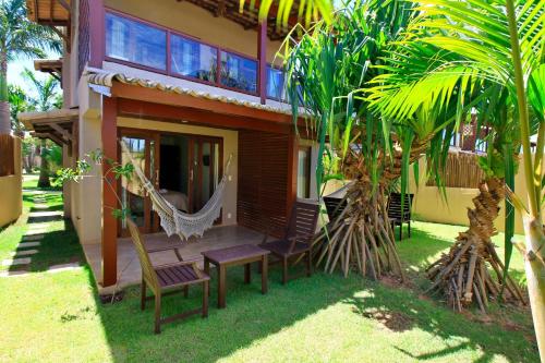 a house with a hammock in front of it at Pipa Beleza Suítes in Pipa