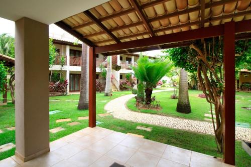 a view of a courtyard with trees and a building at Pipa Beleza Suítes in Pipa