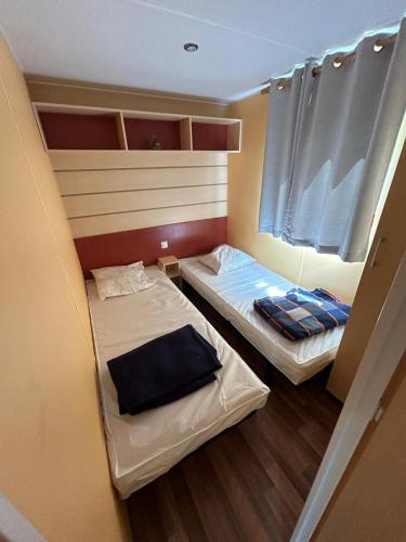 Cette petite chambre comprend 2 lits. dans l'établissement Mobilhome 3 Ch climatisé à 45 mn de Paris, à Saint-Chéron