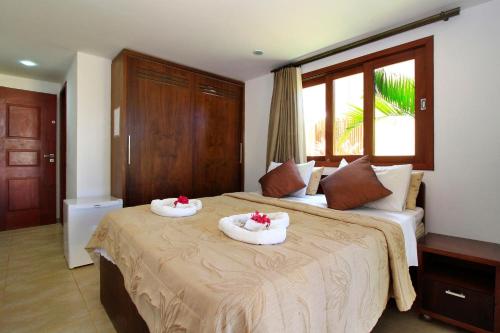 a hotel room with two beds with towels on them at Pipa Beleza Suítes in Pipa