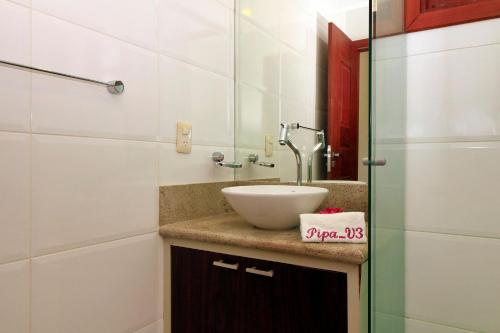 a bathroom with a sink and a mirror at Pipa Beleza Suítes in Pipa