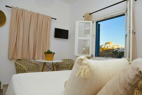 a living room with a couch and a window at Belvedere Studios in Astypalaia Town