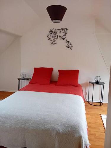 une chambre avec un lit blanc avec des oreillers rouges dans l'établissement Maison à Eu proche centre ville et baie de Somme, à Eu