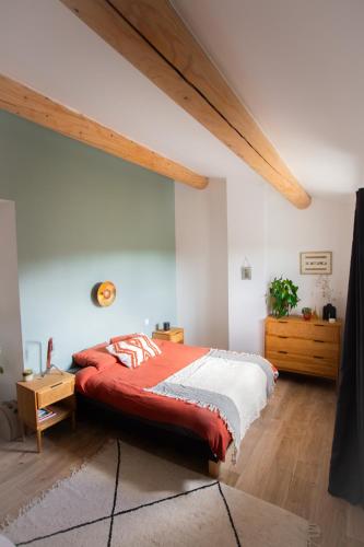 une chambre avec un grand lit avec une couverture rouge dans l'établissement Maison avec jardin, à Saumane-de-Vaucluse