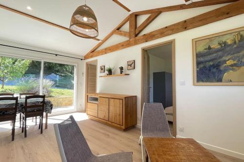 a dining room with a table and chairs and a window at maisonnette entre bois et champs in Crest