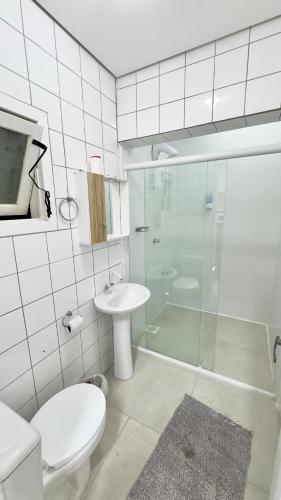 a bathroom with a toilet and a sink and a shower at Hotel das Palmas in Florianópolis