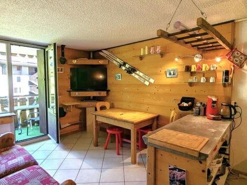 - une cuisine avec une table et une télévision dans la chambre dans l'établissement Appartement cosy au cœur de La Clusaz, ski au pied, avec terrasse et WiFi - FR-1-459-229, à La Clusaz