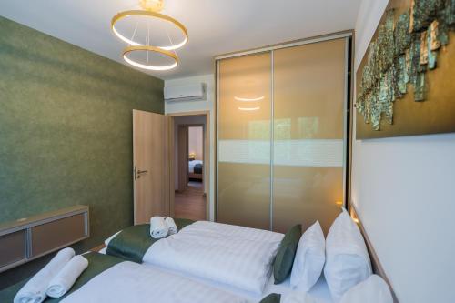 a bedroom with a large bed and a glass wall at Aurea Apartman in Siófok