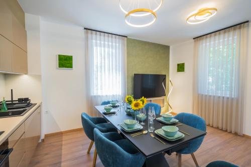 a dining room with a table and blue chairs at Aurea Apartman in Siófok