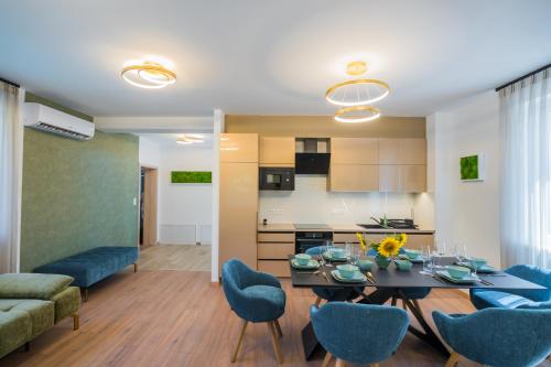 a living room and kitchen with a table and chairs at Aurea Apartman in Siófok