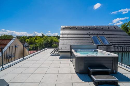 a deck with a hot tub on top of a house at Aurea Apartman in Siófok