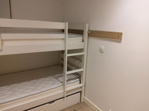 Cette chambre comprend un petit placard avec des lits superposés blancs. dans l'établissement Résidence Le Genevrier - Très joli appartement 2 pièces en plein centre de Méribel dans une résidence calme MAE-0814, à Les Allues