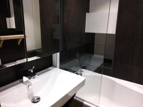une salle de bain avec un lavabo blanc et une baignoire dans l'établissement Résidence Le Genevrier - Très joli appartement 2 pièces en plein centre de Méribel dans une résidence calme MAE-0814, à Les Allues