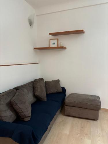a living room with a blue couch and a stool at Casa Luna in Ventimiglia