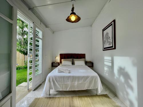 a bedroom with a bed in a white room at Au bout du jardin in Carthage