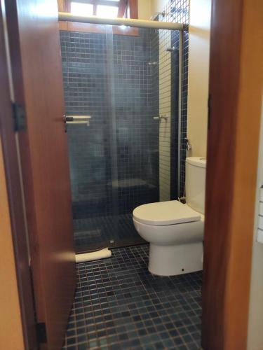 a bathroom with a toilet and a glass shower at Hotel Pousada Santa Rita in Ribeirão Preto