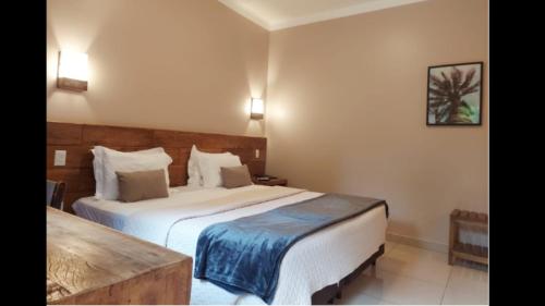 a hotel room with a bed and a table at Hotel Pousada Santa Rita in Ribeirão Preto