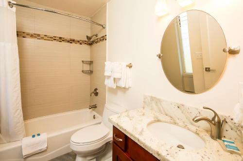 a bathroom with a sink and a toilet and a mirror at Castle Kauai Kailani in Kapaa