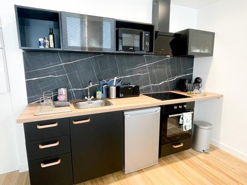a small kitchen with a sink and a stove at Le petit loft in Brest
