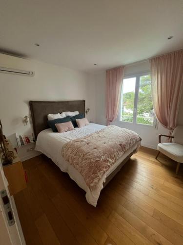une chambre avec un grand lit avec des rideaux roses dans l'établissement Villa de charme avec piscine à proximité des plages, à Saint-Raphaël