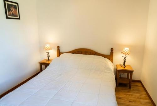 - une chambre avec un lit blanc et 2 lampes sur les tables dans l'établissement Résidence Les Hauts De Preclaux - Appartement cosy sur les pistes des Orres 1800 MAE-0211, aux Orres