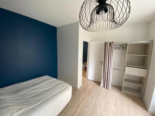 une chambre avec un lit et un mur bleu dans l'établissement Longère en Centre-Ville, à Brest