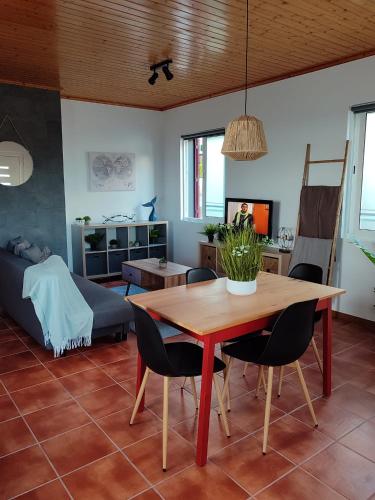 a living room with a wooden table and chairs at Casa do Moinho in Lajes do Pico