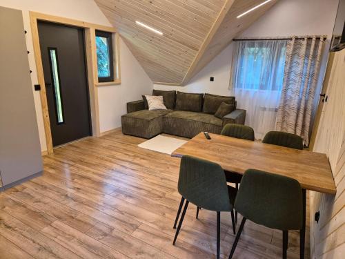 a living room with a couch and a table at Apartament z prywatna wanną hydromasaż - U Parów in Białka Tatrzanska