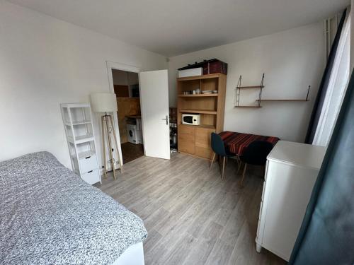 une chambre avec un lit, un bureau et une table dans l'établissement Appartement vue Marie Vincennes, à Vincennes