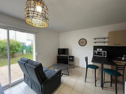 un salon avec un canapé et une table et une cuisine dans l'établissement Les Tilleuls, à Saint-Planchers