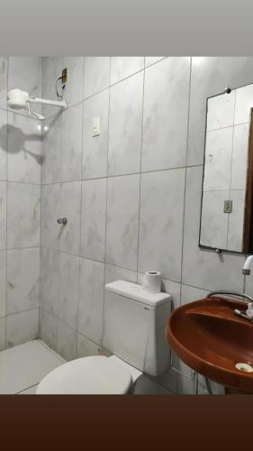 a bathroom with a toilet and a sink and a mirror at Casa Festival de Inverno Garanhuns in Garanhuns