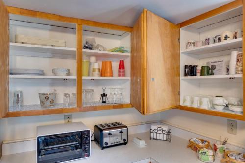 a kitchen with wooden cabinets and a toaster oven at Peaceful Horseheads Hideaway with Deck and Yard! in Horseheads