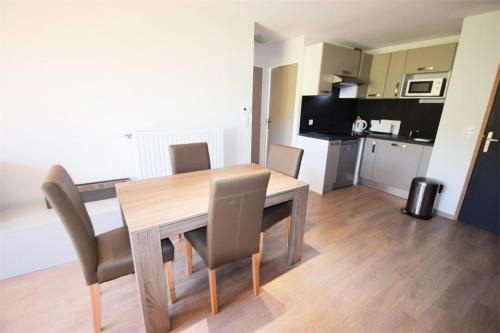 une table de salle à manger avec des chaises et une cuisine dans l'établissement Résidence Front De Neige - 3 Pièces 6 pers LE FRONT DE NEIGE - WIFI PLAGNE VILLAGES MAE-9384, à Aime La Plagne