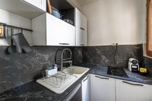 a kitchen with white cabinets and a sink at Le cocon Bourbonnoux in Bourges